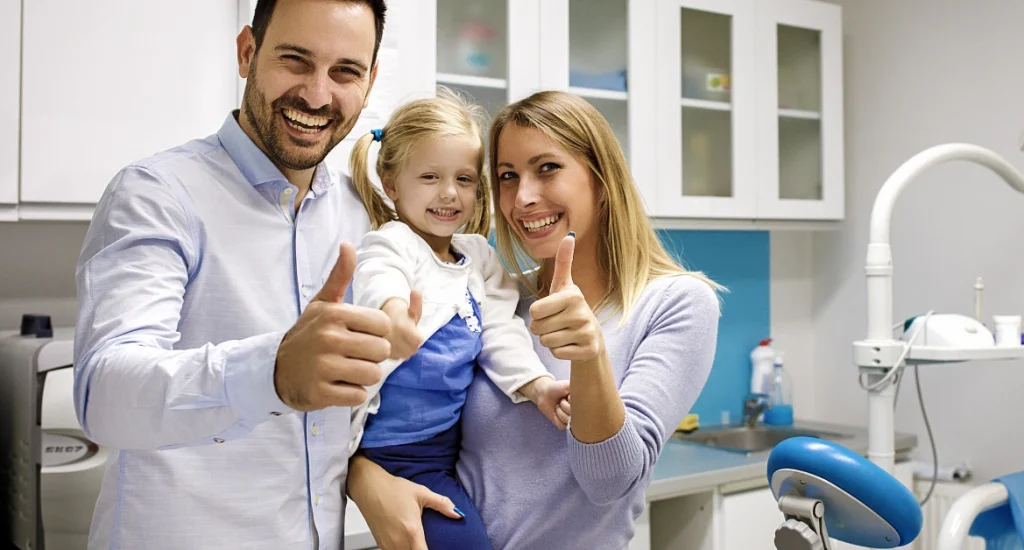 Happy Family Giving Thumbs Up at Dental Office